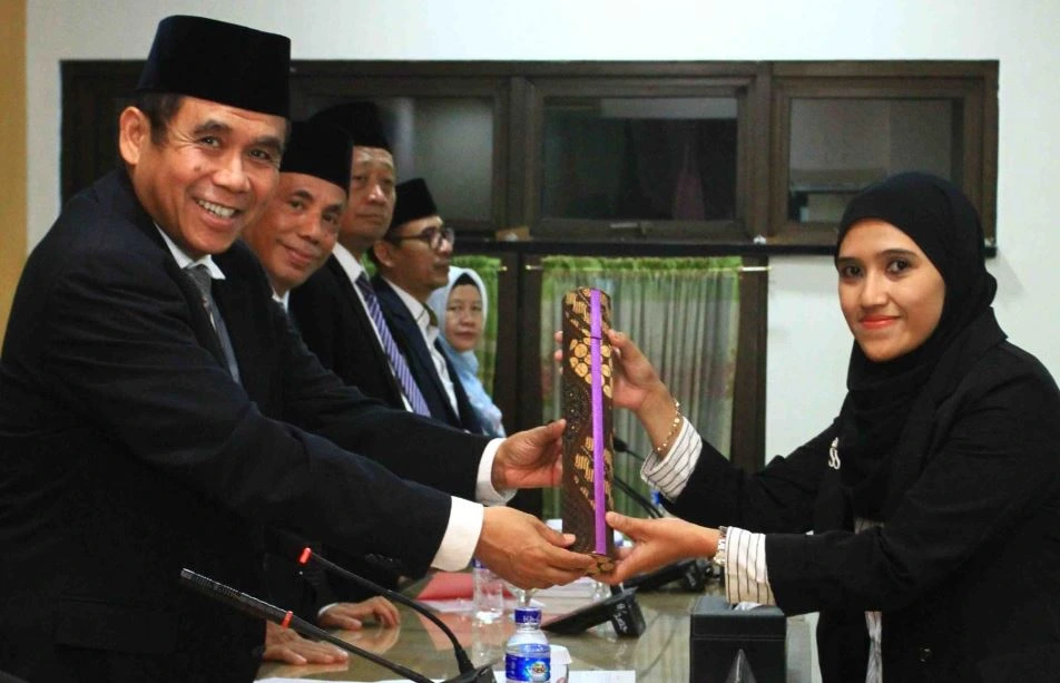 Siti Lailiyah menerima tabung kelulusan Doktor UIN Walisongo dari ketua sidang