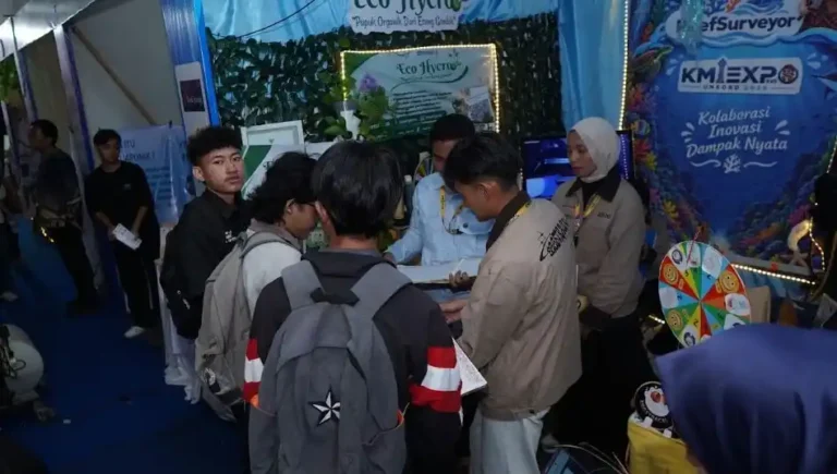 Sejumlah mahasiswa sedang berdiskusi di depan stan pameran inovasi pupuk organik dengan latar belakang spanduk KMI Expo Unsoed 2026 bertuliskan Kolaborasi Inovasi Dampak Nyata.