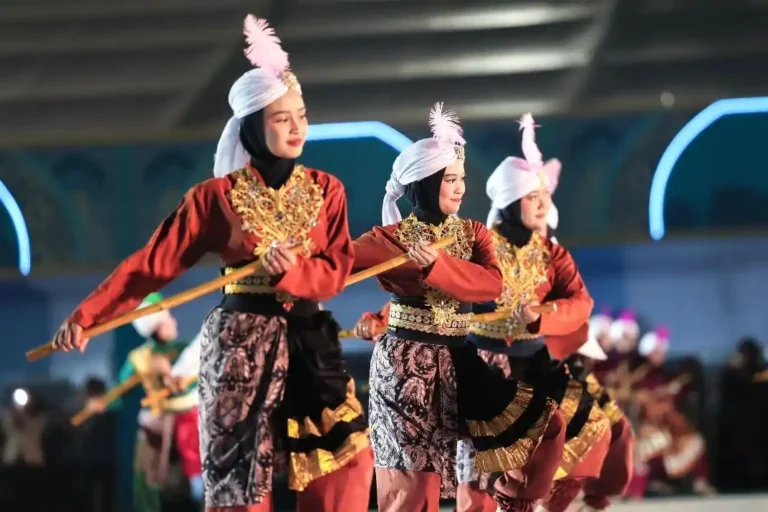Sejumlah penari wanita berhijab menampilkan tarian kolosal tradisional dengan properti tongkat pada malam kemegahan penutupan MTQ Nasional 2026 di Lapangan Simpang Lima Semarang.