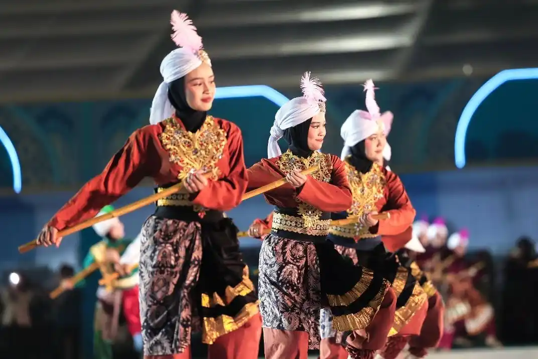 Sejumlah penari wanita berhijab menampilkan tarian kolosal tradisional dengan properti tongkat pada malam kemegahan penutupan MTQ Nasional 2026 di Lapangan Simpang Lima Semarang.