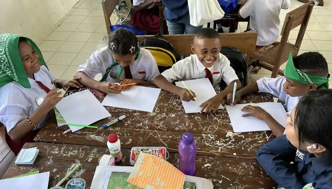 Siswa SD Negeri Soom tertawa ceria saat menggambar rancangan tata ruang wilayah Papua di atas meja kayu bersama tim Ekspedisi Patriot Undip