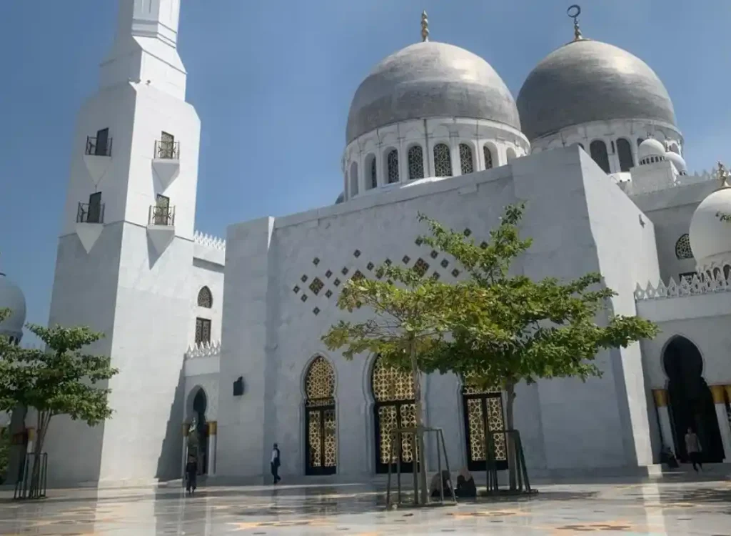 Fasad marmer putih dan kubah besar Masjid Raya Sheikh Zayed Surakarta di bawah langit biru yang cerah sebagai destinasi religi wisata Solo.