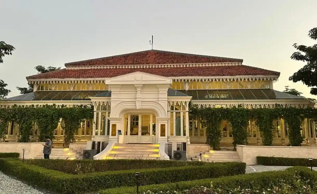 Fasad bangunan klasik berwarna putih dari Resto Pracimasana di kompleks Pura Mangkunegaran dengan latar taman hijau yang tertata rapi sebagai destinasi wisata Solo bernuansa sejarah.