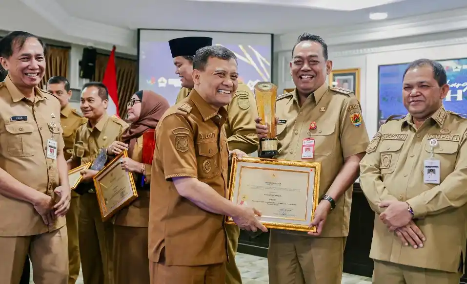 Gubernur Jawa Tengah Ahmad Luthfi tersenyum menyerahkan piagam penghargaan dan piala kepada perwakilan pemerintah daerah dalam acara penganugerahan JDIH 2026 di Semarang.
