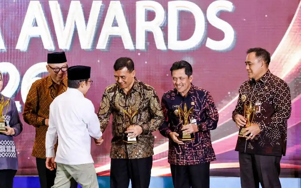 Gubernur Jawa Tengah Ahmad Luthfi memegang trofi dan berjabat tangan dengan Menko Pemberdayaan Masyarakat Muhaimin Iskandar di atas panggung saat menerima penghargaan Mandaya Award 2026 atas keberhasilan penurunan kemiskinan.