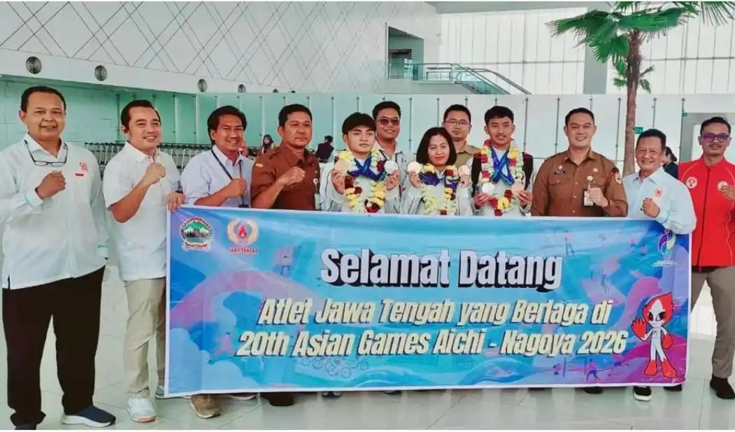 Tiga atlet takraw Jateng peraih medali Asian Games 2026 berkalung bunga berfoto bersama pengurus KONI dan Dispora Jateng membentangkan spanduk penyambutan di Bandara Ahmad Yani Semarang.