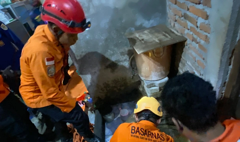 Personel Basarnas Semarang berseragam oranye dan helm pengaman mengevakuasi jasad lansia berusia 97 tahun yang jatuh ke sumur di Kelurahan Karangayu, Semarang Barat.