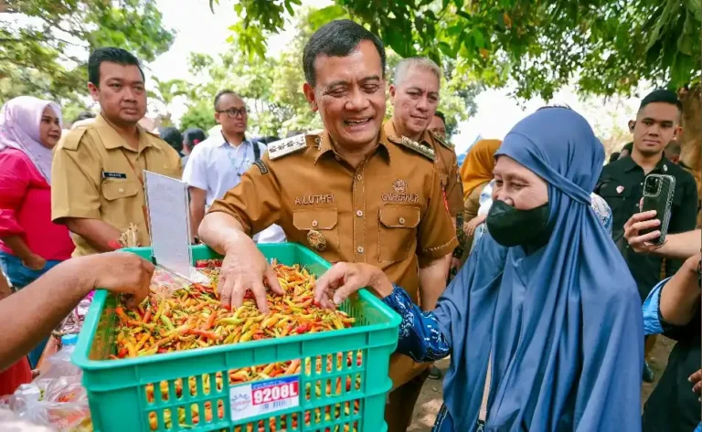 Gubernur Jawa Tengah Ahmad Luthfi berbincang dengan warga sambil memegang tumpukan cabai di keranjang hijau saat meninjau Gerakan Pangan Murah Jateng di Ungaran.