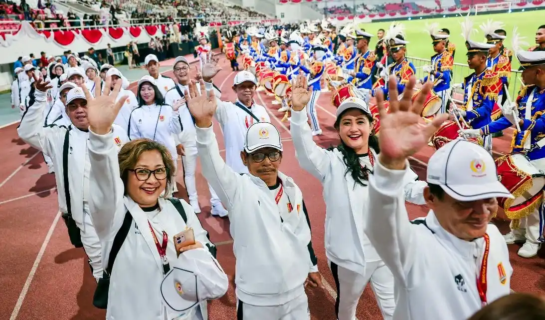 Barisan kontingen berjaket putih melambaikan tangan diiringi marching band dalam kemeriahan pembukaan Porprov Jateng 2026 di Stadion Jatidiri Semarang