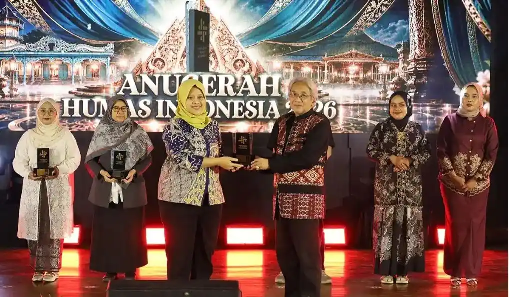 Direktur Jejaring Media, Komunitas dan Komunikasi Publik Undip, Nurul Hasfi, menerima piala penghargaan dari dewan juri dalam malam puncak The 8th Anugerah Humas Indonesia (AHI) 2026 di Surakarta.