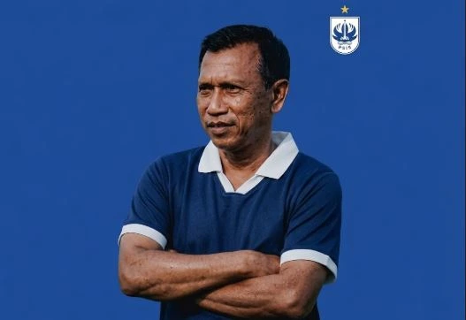 Pelatih PSIS Semarang Widodo C Putro bersedekap dada mengenakan kaus polo biru gelap, dengan logo PSIS berada di sudut kanan atas.