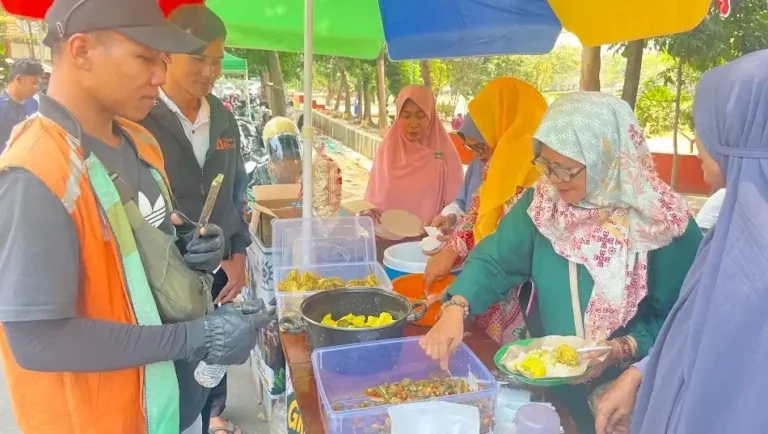 Ibu-ibu PRA Ngaliyan membagikan sepiring sarapan opor ayam kepada pengemudi ojek online dalam inisiatif program makan gratis Semarang yang digelar di jalanan.