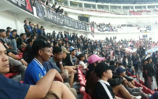Kerumunan suporter Snex PSIS Semarang memadati kursi merah di tribun Stadion Jatidiri dengan latar belakang spanduk dukungan.