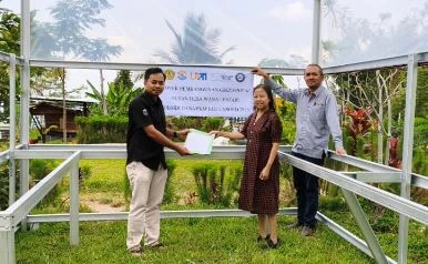 Tim Pengabdi Unsoed bersama pengurus LPHD Wana Lestari berpose di depan fasilitas pembibitan dan pengeringan dalam program pengabdian Hutan Desa Wana Lestari.