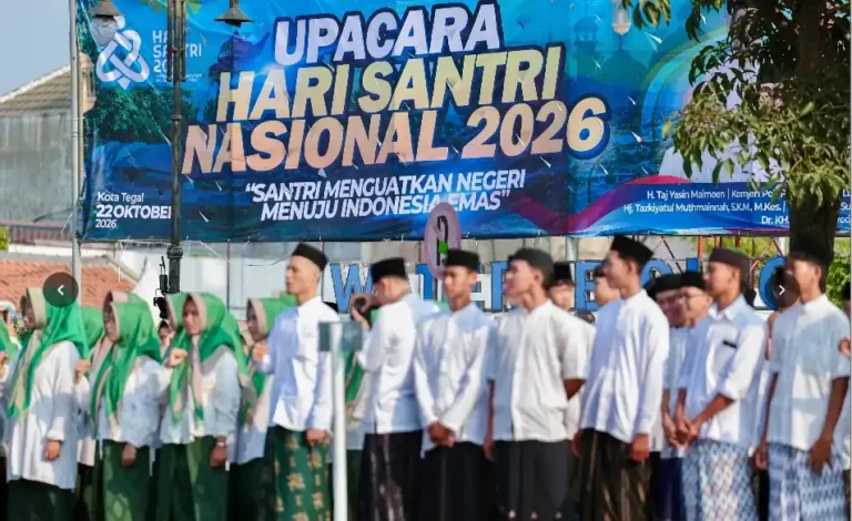 Barisan santri putra dan putri berdiri rapi mengikuti rangkaian Upacara Hari Santri 2026 berlatar spanduk raksasa di Kota Tegal.